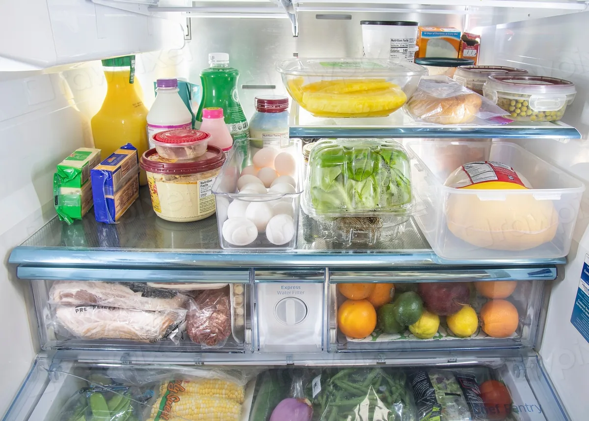 Organized refrigerator with clear bins, produce, and calm everyday storage