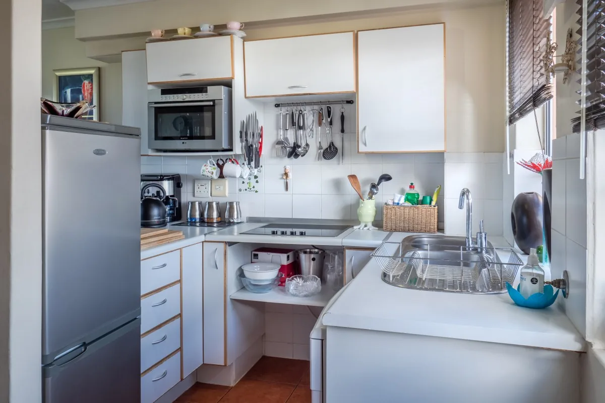 Compact kitchen with stainless steel refrigerator