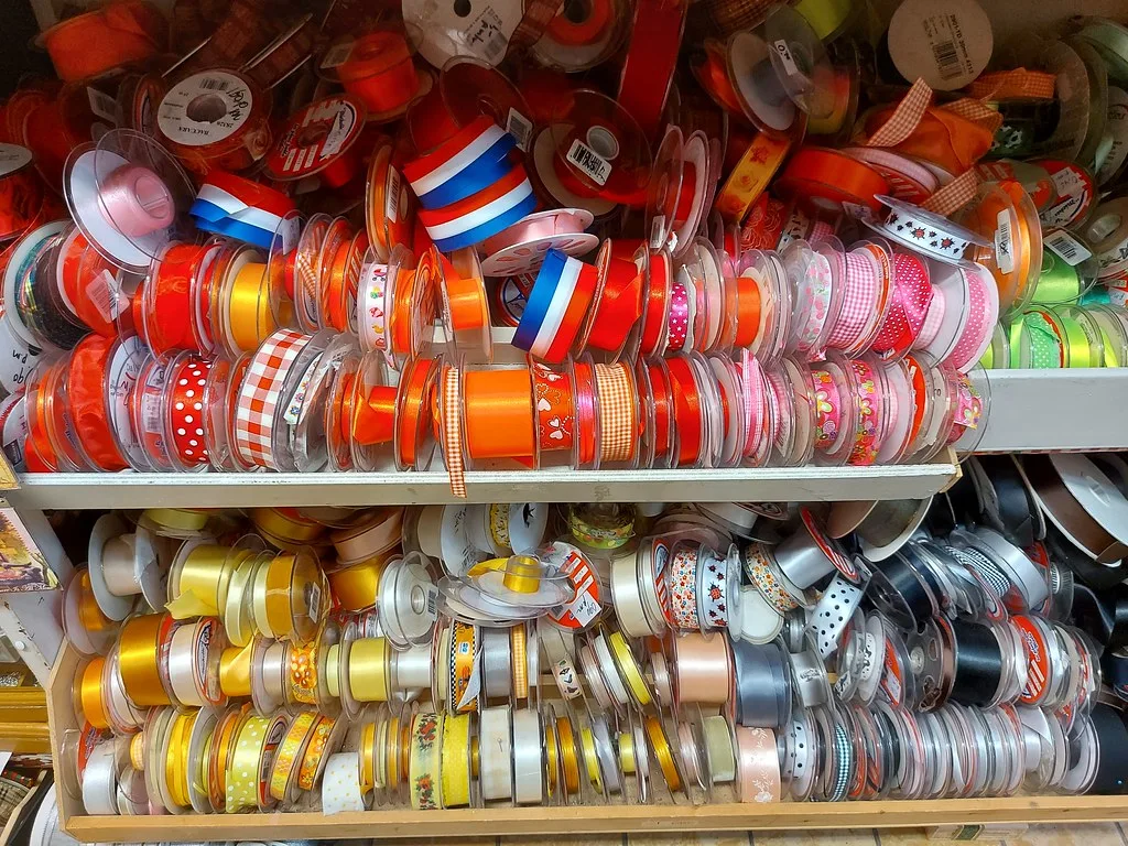 Shelves of colorful ribbon spools sorted by color