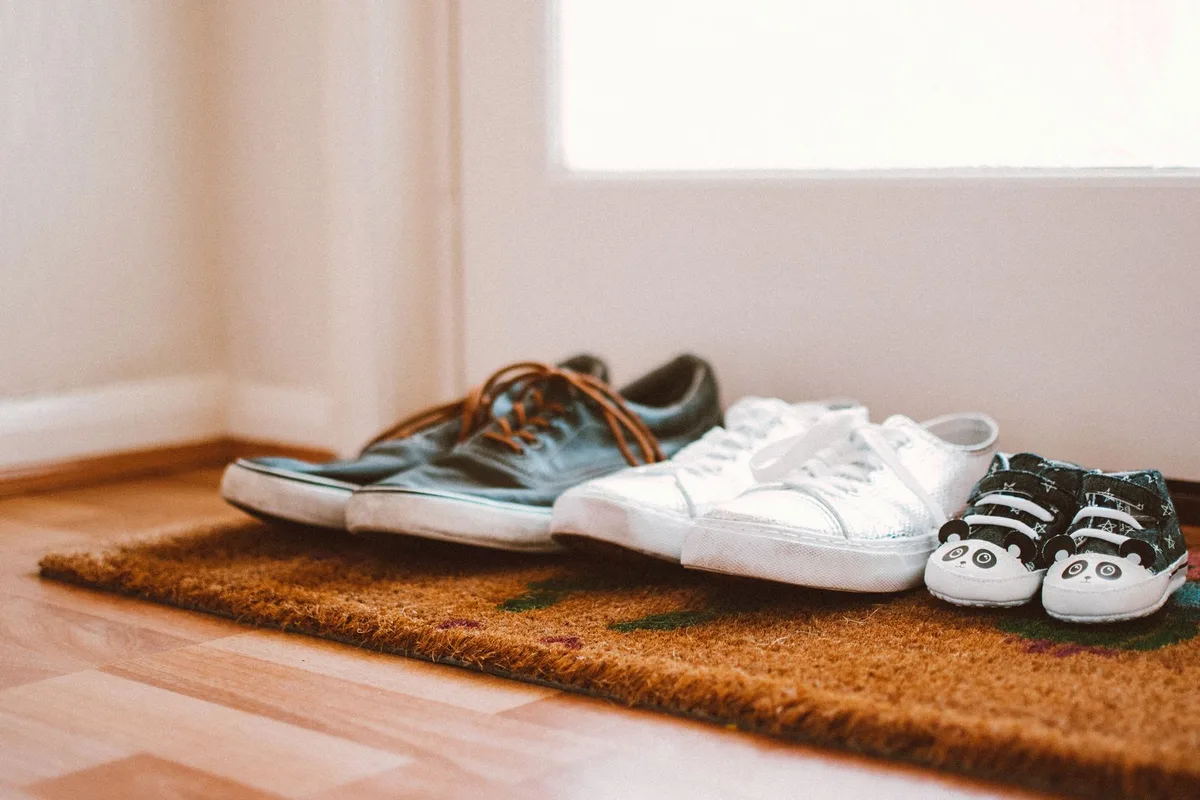 Family shoes lined up on a doormat at the front door