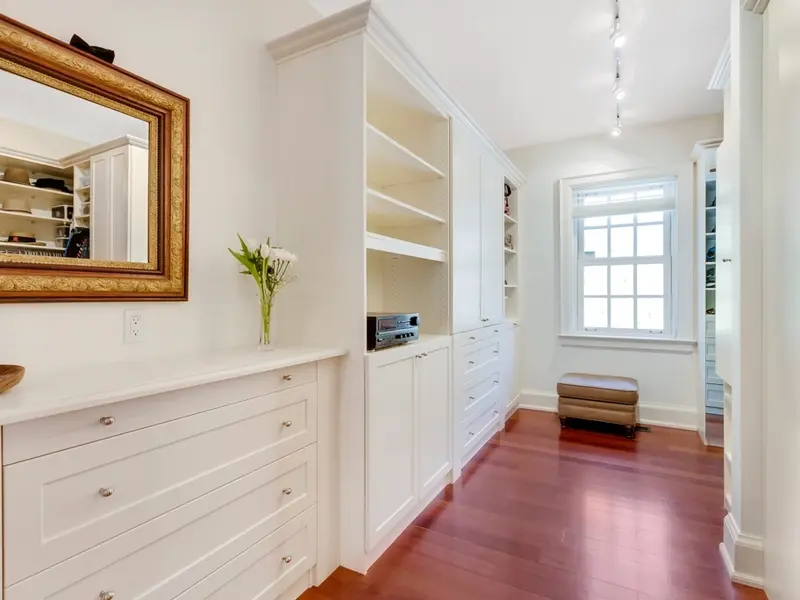 White built-in cabinets and shelves in a bright hallway